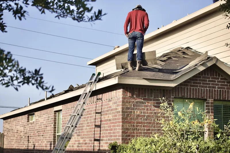 Professional roofer working on a residential roof in Woodside Manor